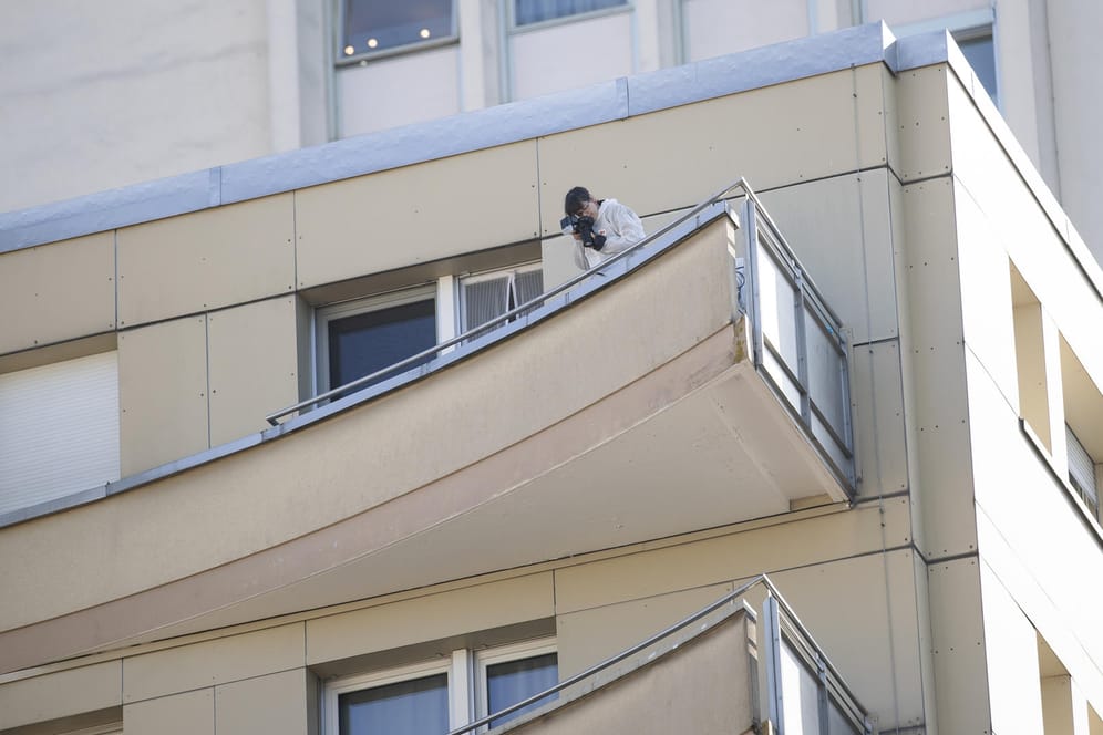 Ein Kriminalpolizist sichert Beweise: Von dem Balkon stürzten vier Mitglieder einer Familie in den Tod.