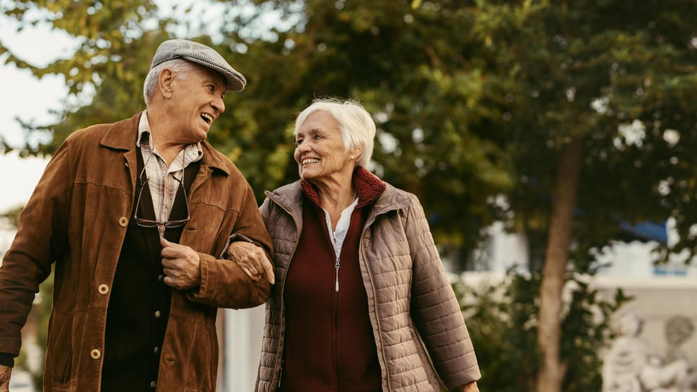Älteres Paar beim Spaziergang (Symbolbild): Wessen Rente hoch genug ist, um den Lebensstandard zu halten, kann sich glücklich schätzen.