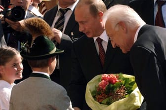 Wladimir Putin (M.) mit Bayerns Ministerpräsident Edmund Stoiber bei seinem Besuch in Bayern 2006 (Archivbild). Mehrfach wurde der heutige Kriegsverbrecher in München empfangen.