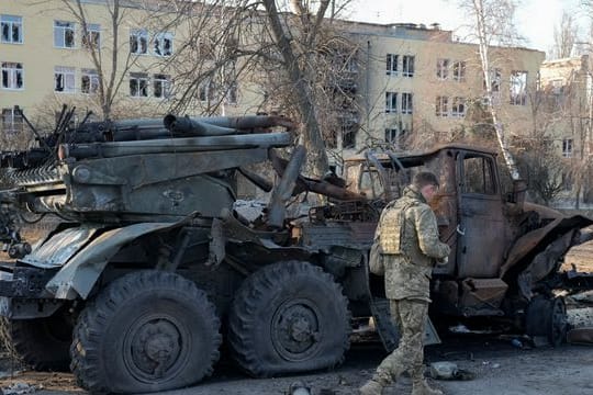 Ein ukrainischer Soldat geht in Charkiw an einem zerstörten russischen Artilleriesystem vorbei.