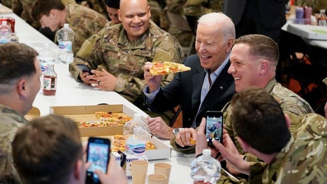 US-Präsident Biden (M) isst während seines Besuchs bei der 82.