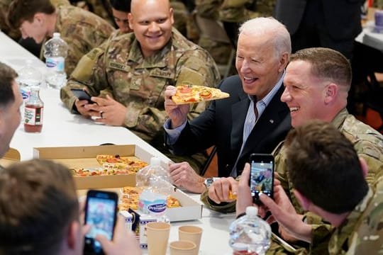 US-Präsident Biden (M) isst während seines Besuchs bei der 82.