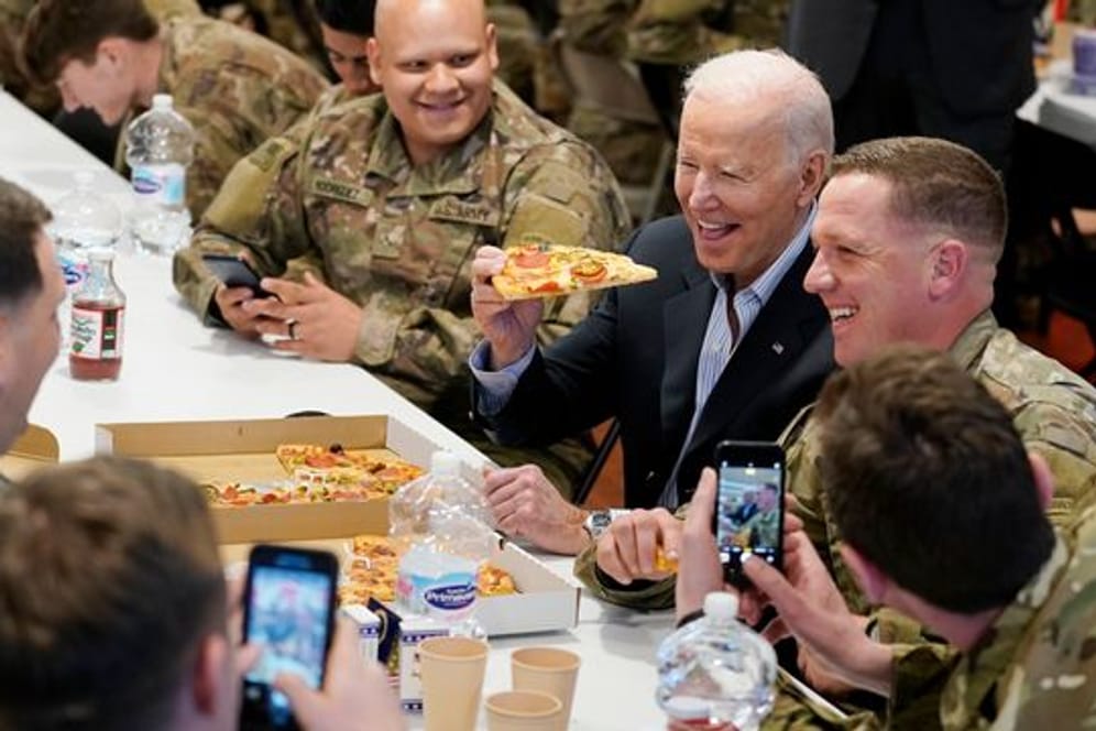 US-Präsident Biden (M) isst während seines Besuchs bei der 82.