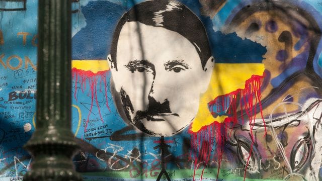 Auf der sogenannten John-Lennon-Mauer in Prag hat ein Unbekannter den russischen Präsidenten Wladimir Putin angesichts des Ukraine-Kriegs als Adolf Hitler dargestellt.