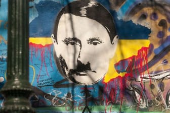Auf der sogenannten John-Lennon-Mauer in Prag hat ein Unbekannter den russischen Präsidenten Wladimir Putin angesichts des Ukraine-Kriegs als Adolf Hitler dargestellt.