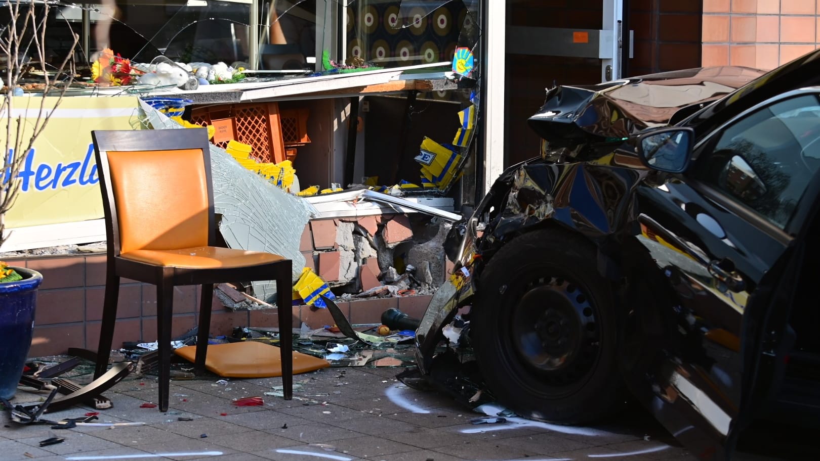 Das zerstörte Auto vor der Bäckerei: Auf dem Bürgersteig wurden eine Mutter und ihr Kind von dem Wagen getroffen. Das zerstörte Auto vor der Bäckerei: Auf dem Bürgersteig wurden eine Mutter und ihr Kind von dem Wagen getroffen.