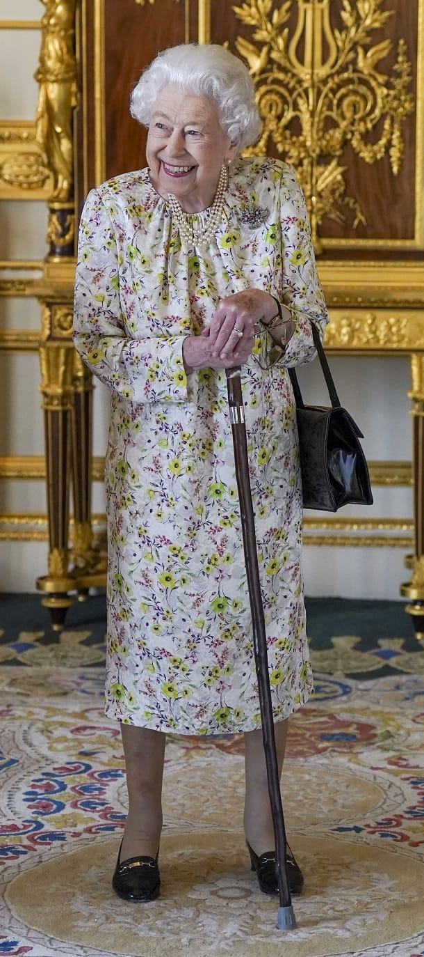 Die Queen stützt sich auf einen Gehstock.