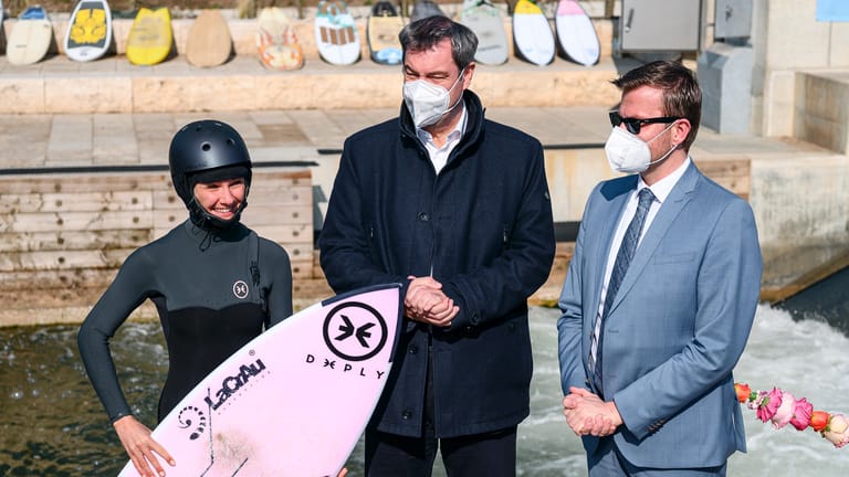 Ministerpräsident Söder und Oberbürgermeister Marcus König mit einer Surferin: Am Fuchsloch in Nürnberg darf nun offiziell gesurft werden.