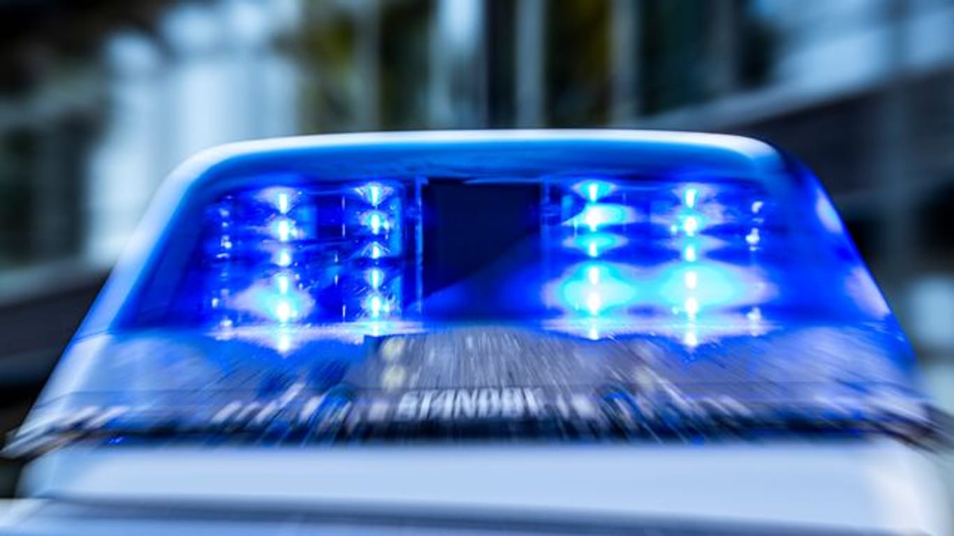 Ein Blaulicht leuchtet auf dem Dach eines Polizeiwagens (Symbolbild): Einem Mann wurden die Ohrringe abgerissen.
