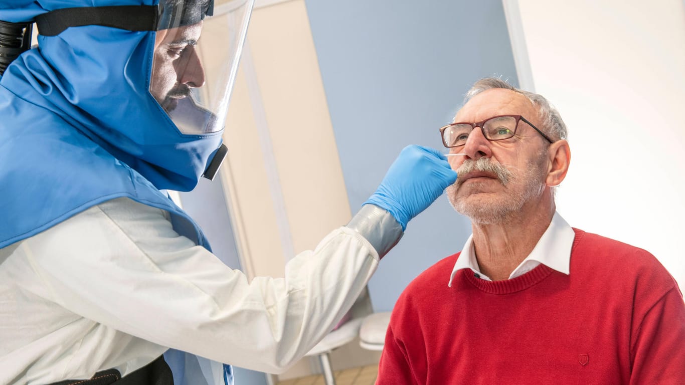 Ein Arzt führt bei einem älteren Mann PCR-Test durch (Symbolbild): Noch immer sind die Infektionszahlen in Deutschland sehr hoch.