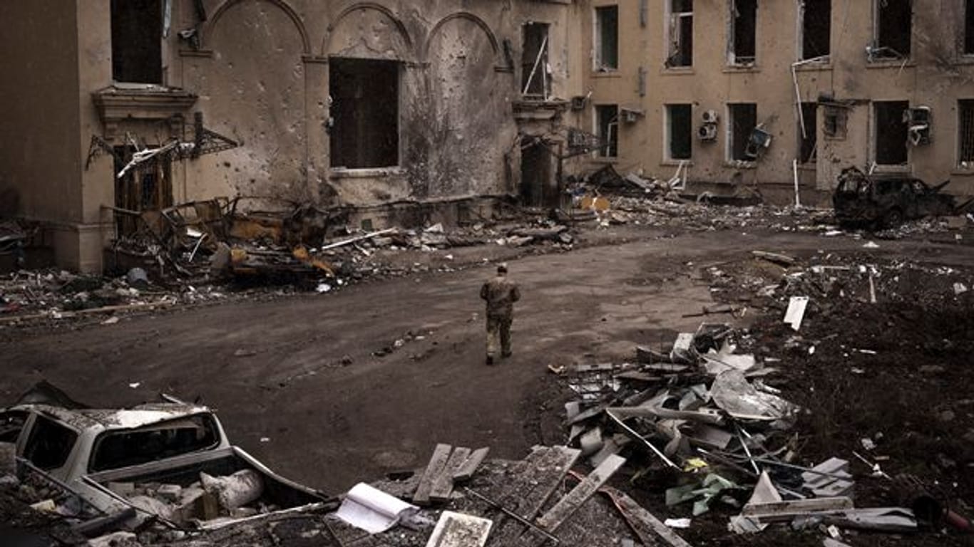 Ein ukrainischer Soldat geht an einem schwer beschädigten regionalen Verwaltungsgebäude in Charkiw vorbei.