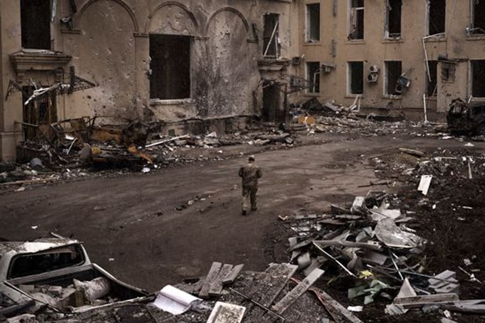 Ein ukrainischer Soldat geht an einem schwer beschädigten regionalen Verwaltungsgebäude in Charkiw vorbei.
