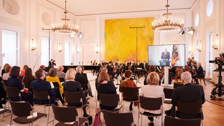 Die Berliner Philharmoniker vor ein paar Dutzend Zuschauern während Bundespräsident Frank-Walter Steinmeier wegen Krankheit per Video zugeschaltet ist.