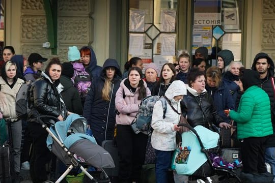 Flüchtlinge mit Kindern warten auf einem Bahnhof im polnischen Przemysl auf einen Transport.