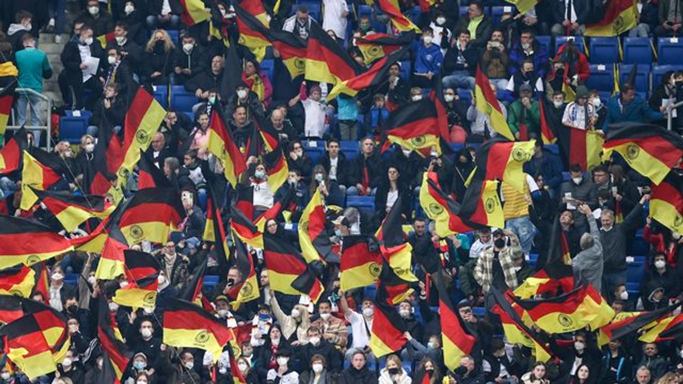 Fans schwenken vor dem Spiel Deutschlandfahnen auf der Tribüne.