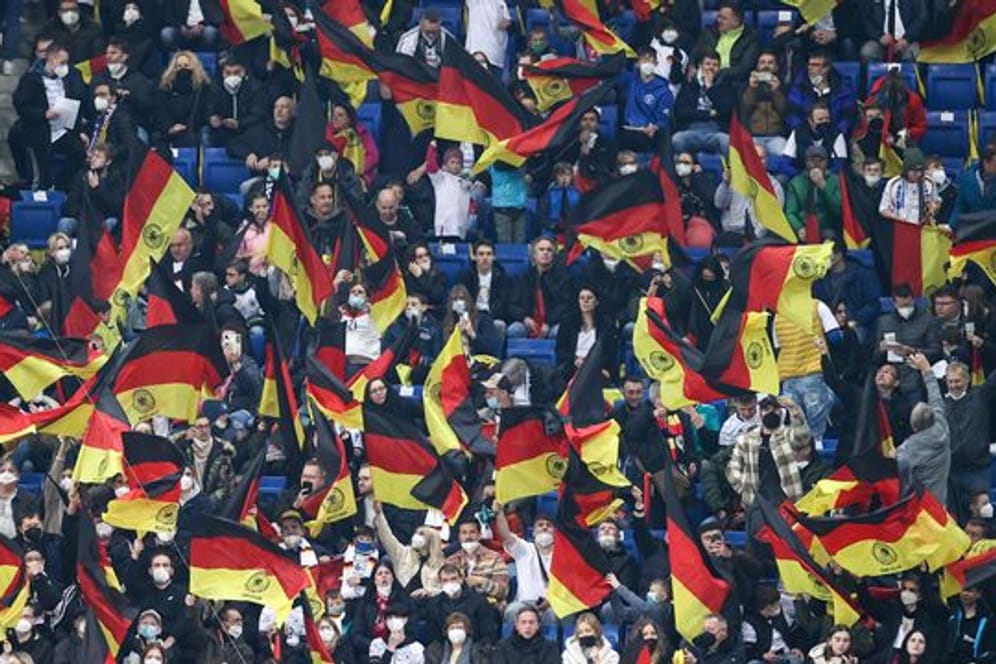Fans schwenken vor dem Spiel Deutschlandfahnen auf der Tribüne.