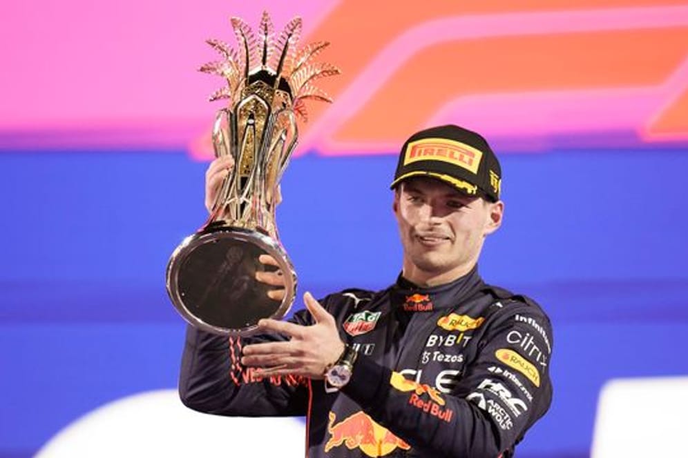 Rennfahrer Max Verstappen hält den Grand-Prix-Pokal in die Höhe.