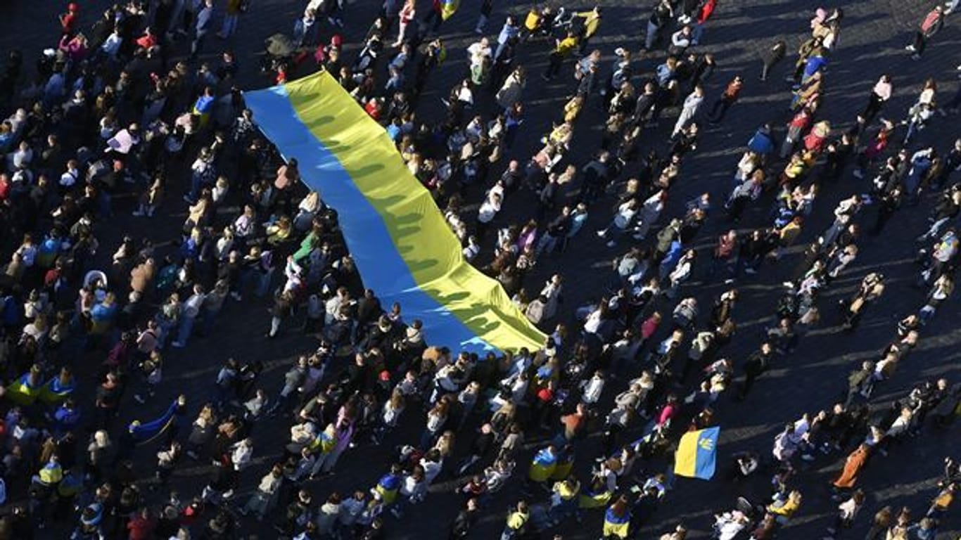 Menschen schauen auf dem Altstädter Ring in Prag die Übertragung des Streaming-Benefizkonzerts "Save Ukraine - #StopWar".