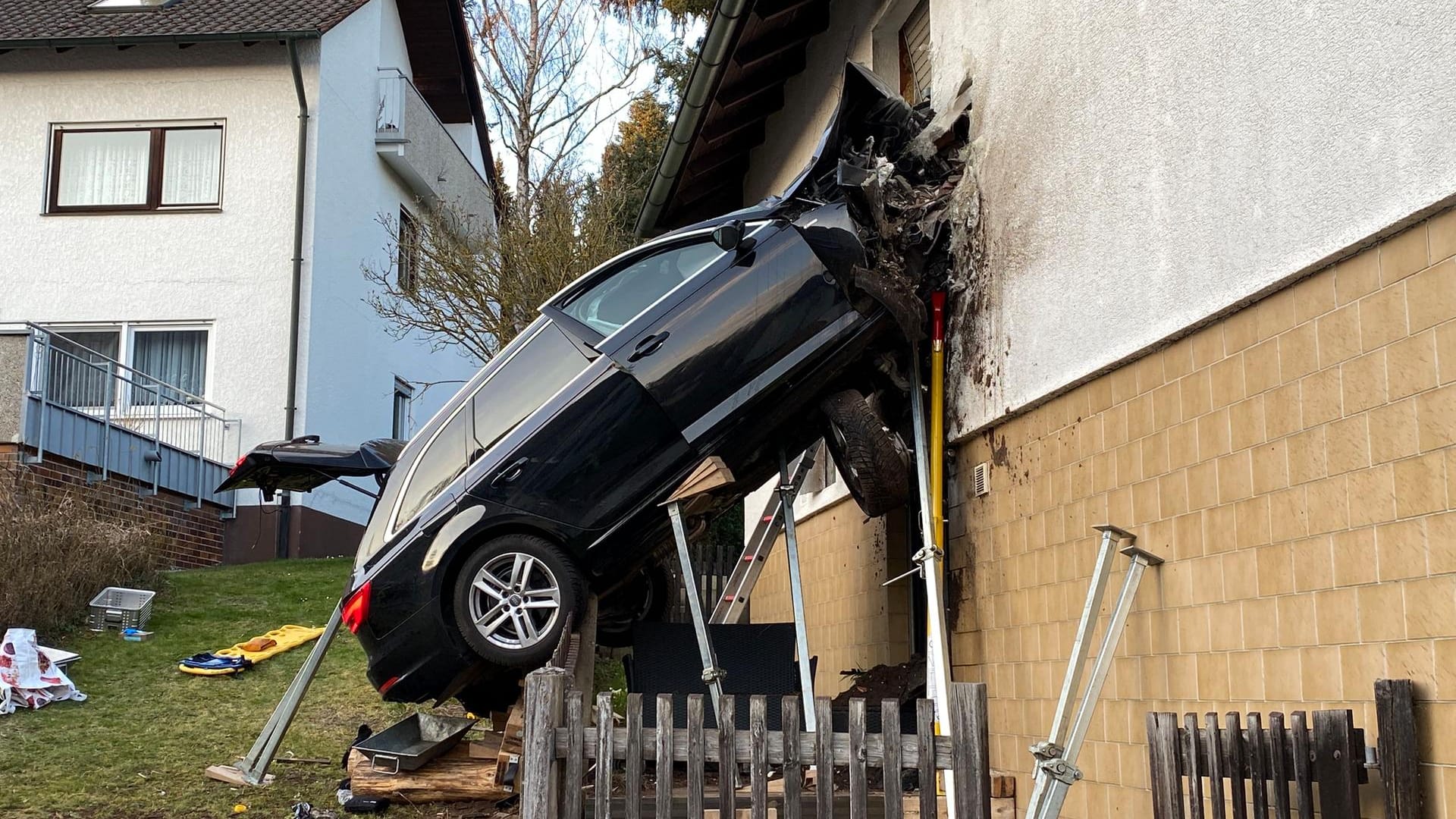 Das Auto hängt in der Hauswand: Ein Mann kam bei dem Unfall ums Leben.