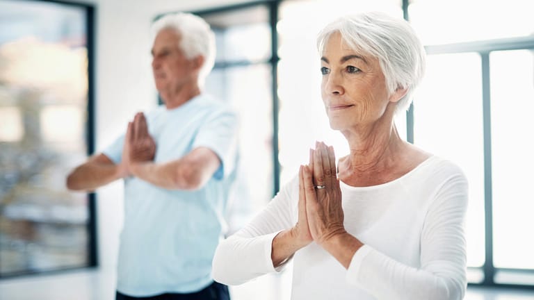 Ältere Menschen praktizieren Yoga