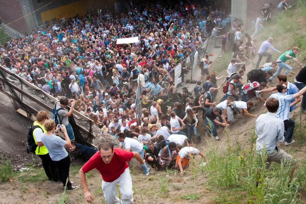 Tausende Raver drängen sich am 24. Juli 2010 auf der Duisburger Loveparade in und vor dem Tunnel, in dem sich eine Massenpanik ereignet hat: Eine Kommission hat das Ereignis aufgearbeitet.