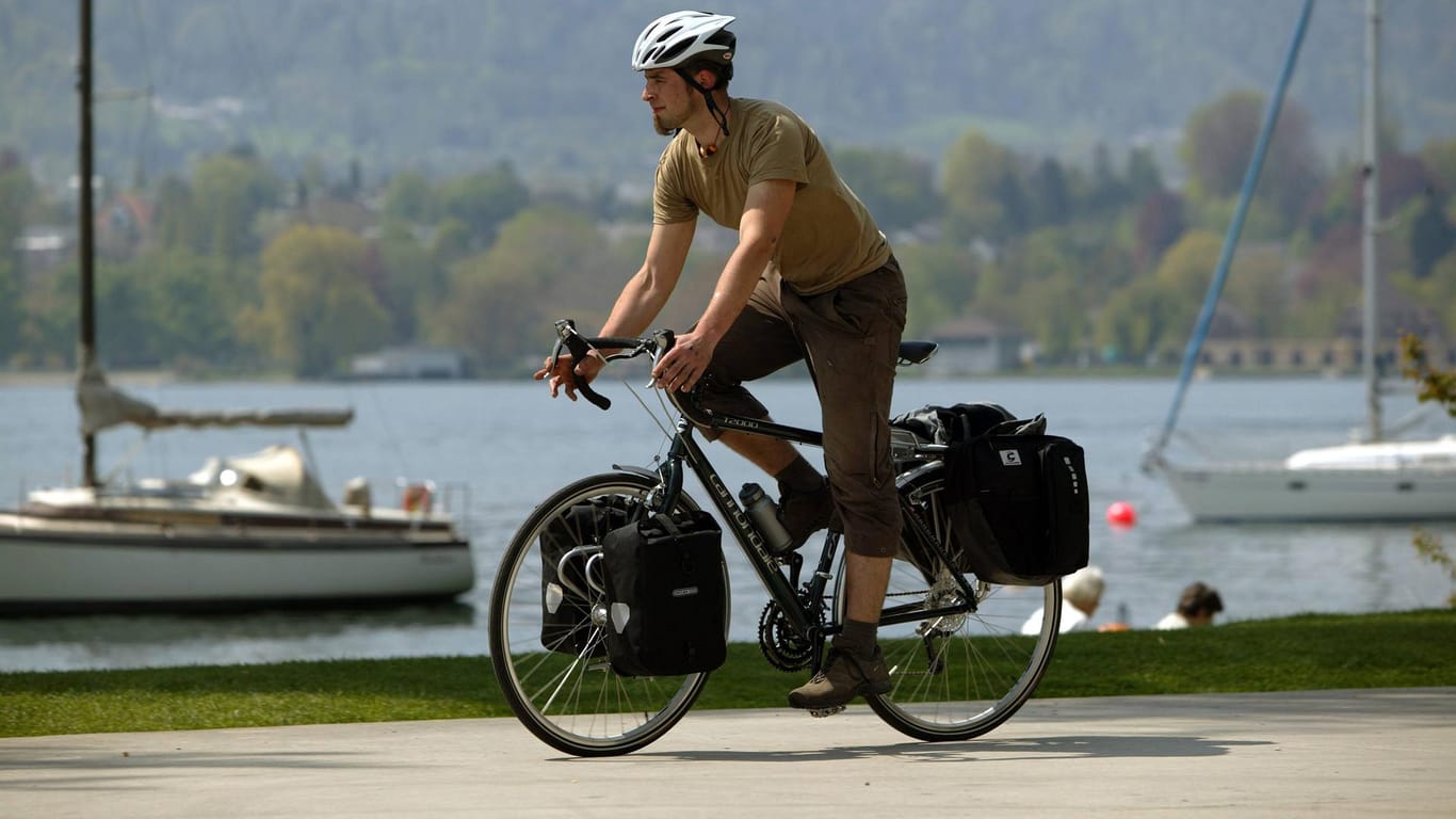 Radfahrer mit vollbepacktem Rad: Taschen am Vorderrad können helfen, das Gewicht besser zu verteilen.