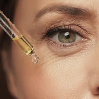 Falten am Auge einer älteren Frau: Bei trockenheitsbedingten Fältchen am Augenrand kann eine Anti-Aging-Pflege viel bewirken. Bei tiefen und altersbedingten Falten jedoch braucht es mehr als reine Hautpflege.