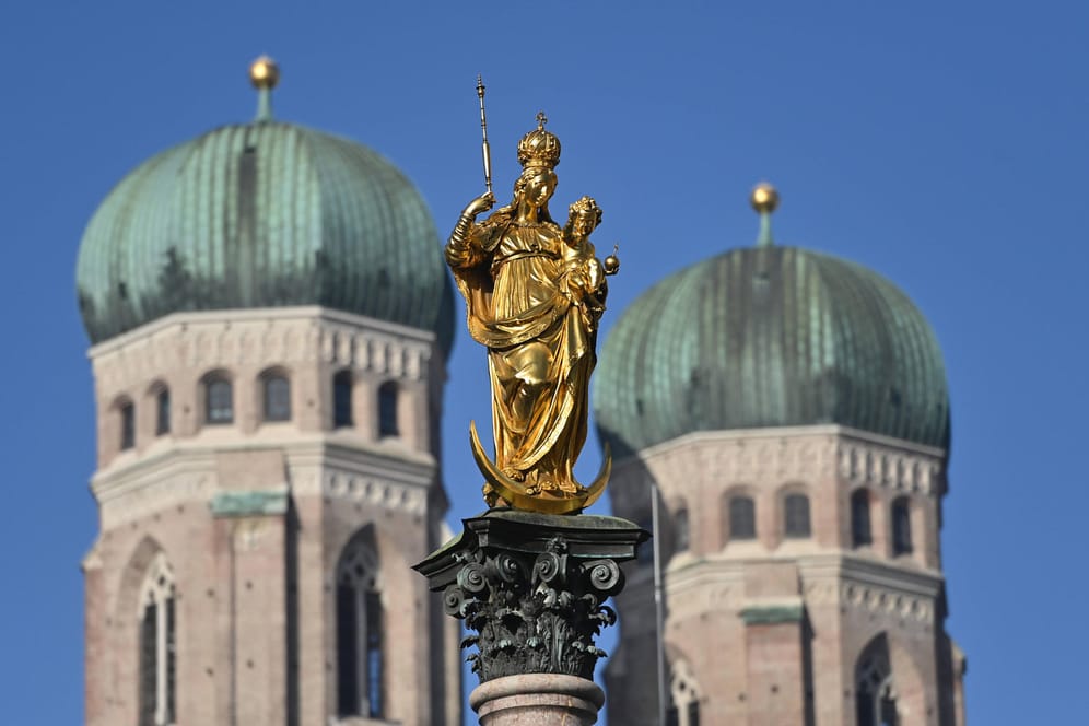 Goldene Madonna der Mariensäule auf dem Marienplatz in München. Im Hintergrund die Türme der Frauenkirche (Archivbild): Der Abgang von Kirchenrichter Wolf ist im Missbrauchsskandal nur ein Tropfen auf dem heißen Stein.