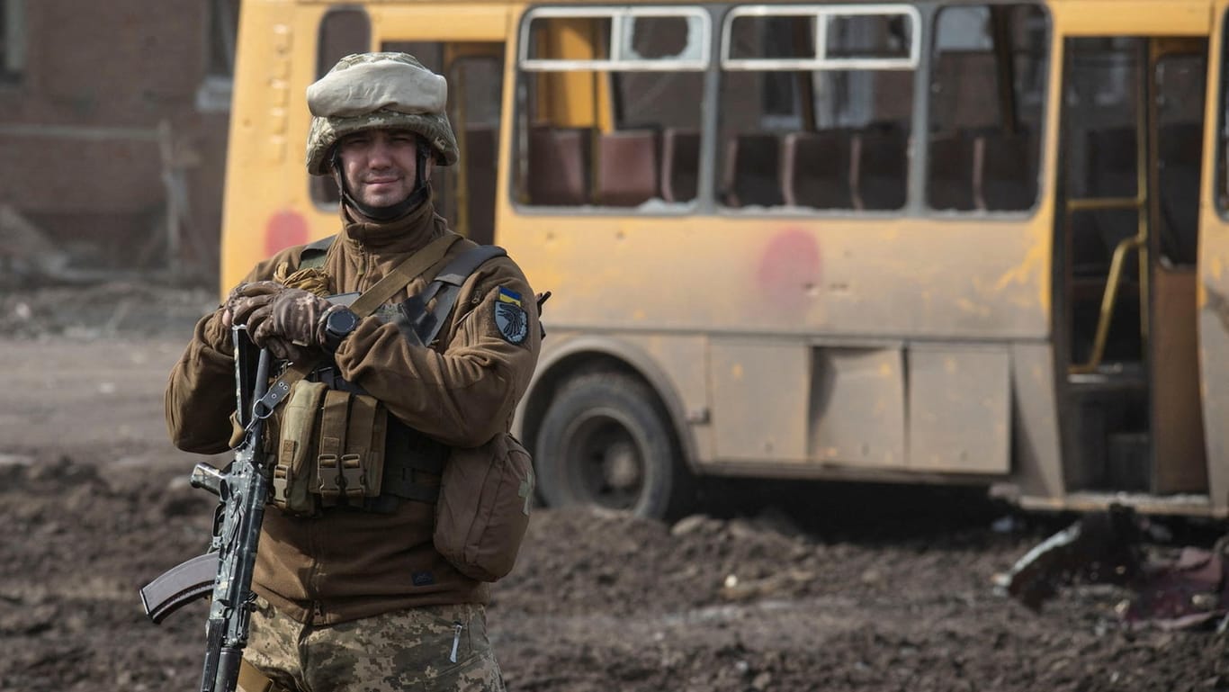 Ein ukrainischer Soldat vor einem zerstörten Schulbus in Trostjanez: Die strategisch wichtige Stadt bei Sumy wurde am Wochenende zurückerobert.