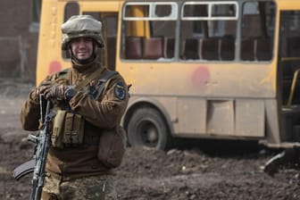 Ein ukrainischer Soldat vor einem zerstörten Schulbus in Trostjanez: Die strategisch wichtige Stadt bei Sumy wurde am Wochenende zurückerobert.