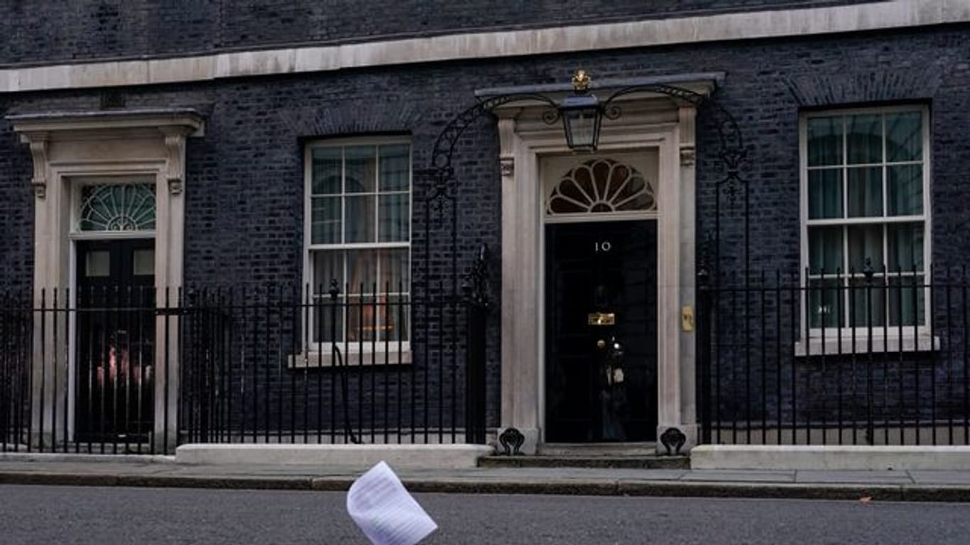 Eine Kopie des Berichts zu den mutmaßlichen Lockdown-Verstößen im britischen Regierungssitz fliegt an der Eingangstür der 10 Downing Street vorbei.
