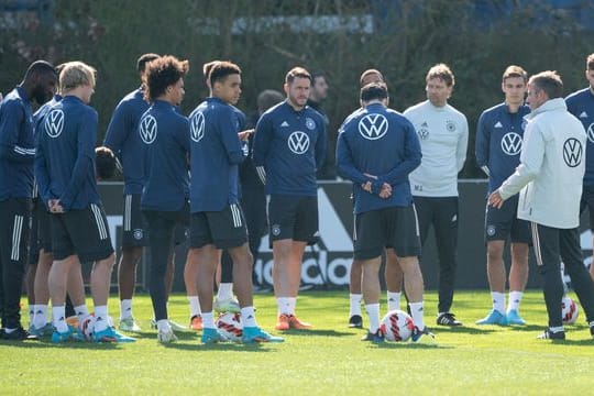 Bundestrainer Hansi Flick (r) wendet sich beim Abschlusstraining an die Spieler der Nationalmannschaft.