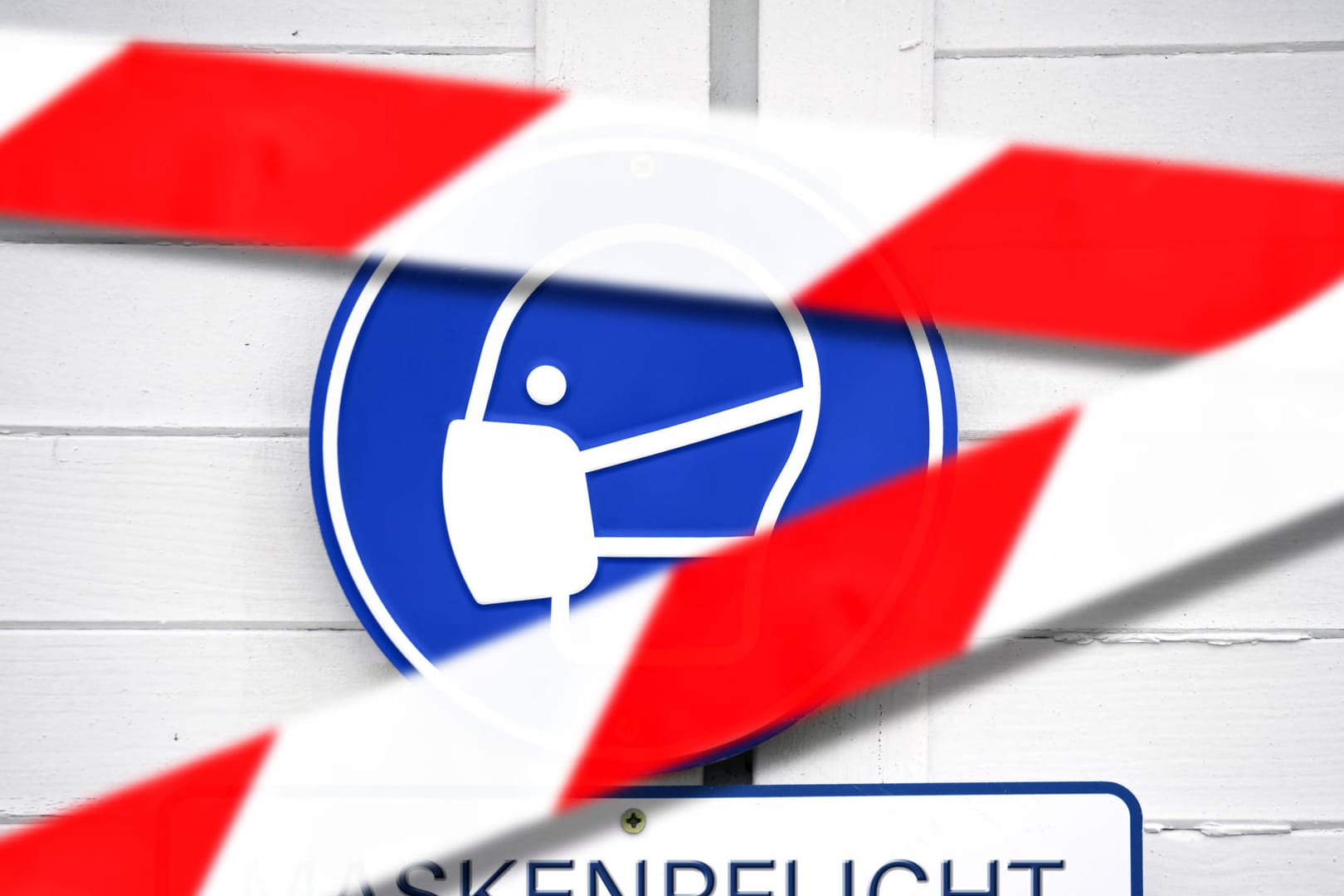 Maskenpflicht-Schild hinter Absperrband (Fotomontage, Symbolbild): Das Kabinett in Bayern lässt die Corona-Regeln auslaufen.