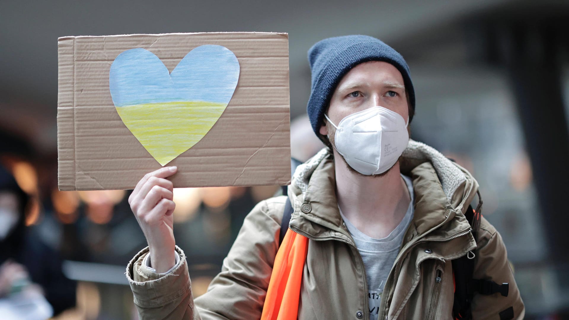 Am Berliner Hauptbahnhof hält ein Mann ein Schild mit einem Herz in den Farben der ukrainischen Flagge (Archivbild): Viele Berliner zeigen sich solidarisch mit der Ukraine, helfen am Hauptbahnhof oder wollen Geflüchtete aufnehmen.