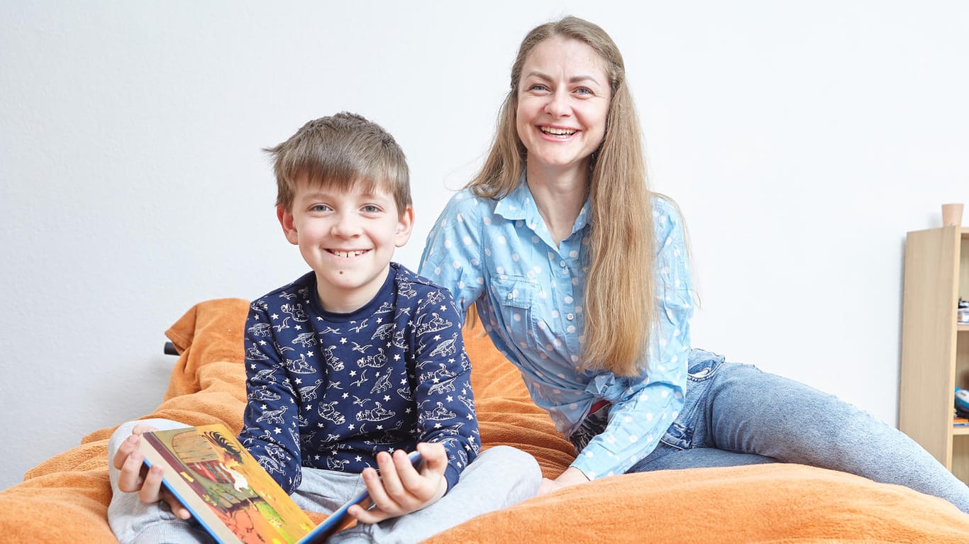 Maria und Andrej sitzen auf ihrem Bett: Am Ende kann der Junge doch noch lachen.