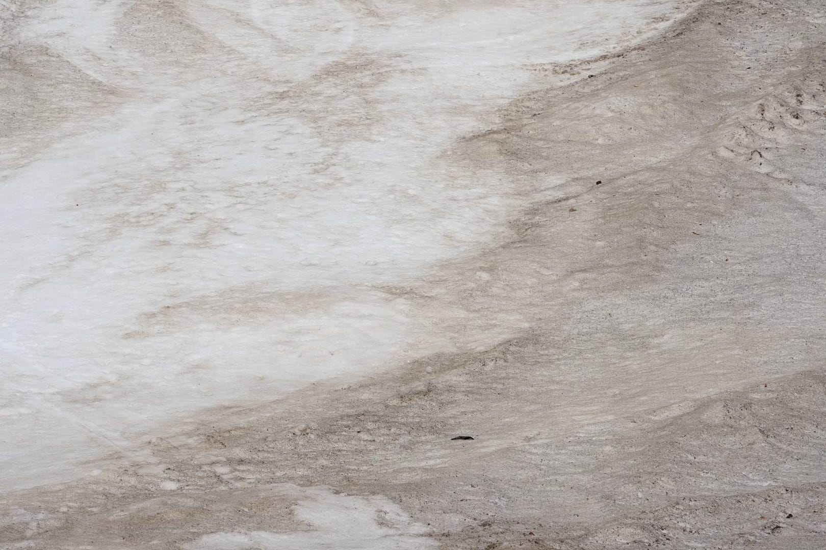 Saharastaub hinterlässt auch auf Schnee seine Spuren (Symbolbild). Nach dem milden März wird es wieder frostig in Bayern. Feiner Saharastaub könnte zudem für spektakuläre Aussichten sorgen.