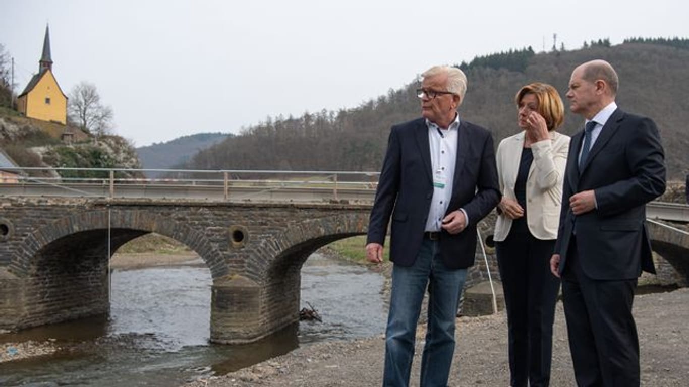 Bundeskanzler Olaf Scholz (SPD) und die rheinland-pfälzische Ministerpräsidentin Malu Dreyer (SPD) am Ufer der Ahr mit Ortsbürgermeister Walter Radermacher (l).