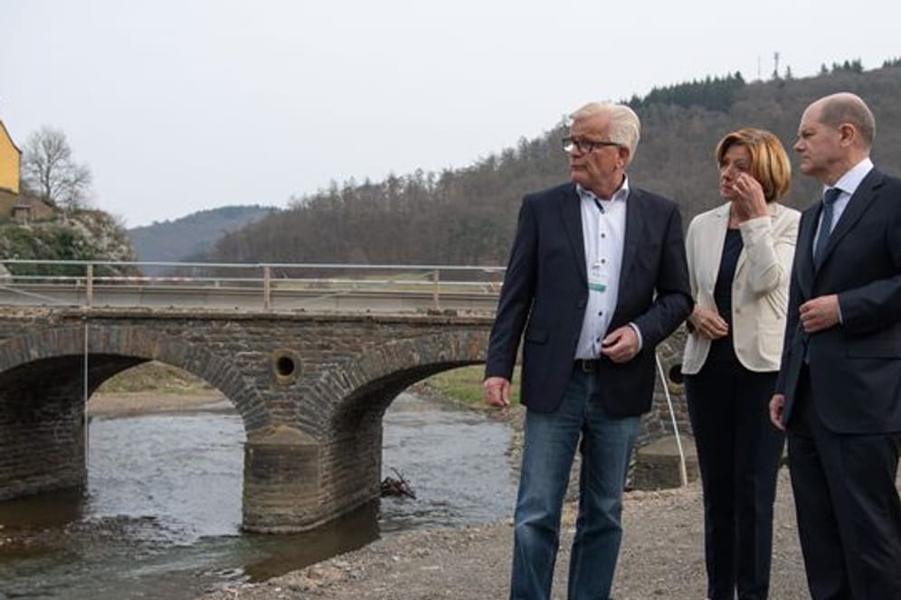 Bundeskanzler Olaf Scholz (SPD) und die rheinland-pfälzische Ministerpräsidentin Malu Dreyer (SPD) am Ufer der Ahr mit Ortsbürgermeister Walter Radermacher (l).