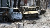 Verbrannte Autos in Mariupol: Zehntausende Menschen haben ihr Zuhause verloren und sind aus der Stadt geflohen. Die Flucht ist jedoch nicht ungefährlich – immer wieder kommt es zu Angriffen auf Zivilisten. Die russische Armee bestreitet, Zivilisten gezielt anzugreifen.