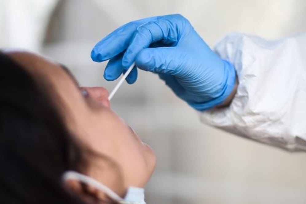 Eine Mitarbeiterin eines Testzentrums nimmt einen Nasenabstrich für einen CoronaTest.