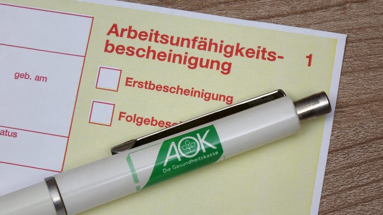 Krankenschein und Kugelschreiber der AOK (Symbolbild): Laut der Krankenkasse hat es in Berlin nie mehr Krankschreibungen gegeben.