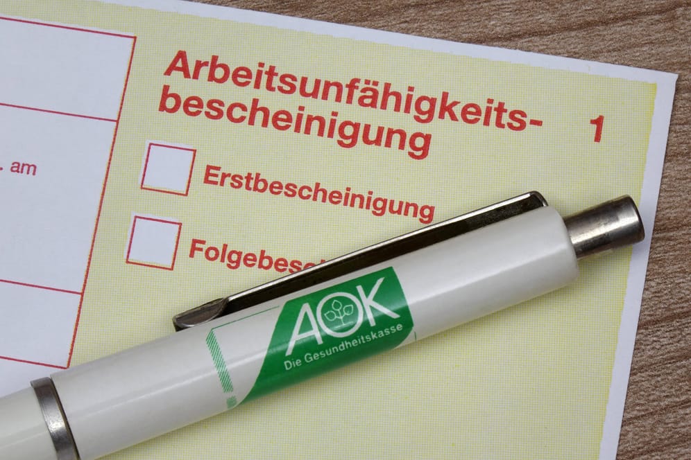 Krankenschein und Kugelschreiber der AOK (Symbolbild): Laut der Krankenkasse hat es in Berlin nie mehr Krankschreibungen gegeben.