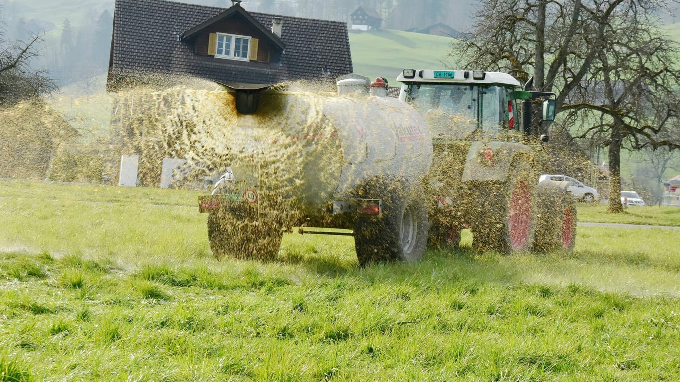 Landwirt mit Traktor und Jaucheanhänger (Symbolbild): Bei einer Großrazzia haben Ermittler ein mutmaßliches illegales Treiben mit Gülle aufgedeckt.