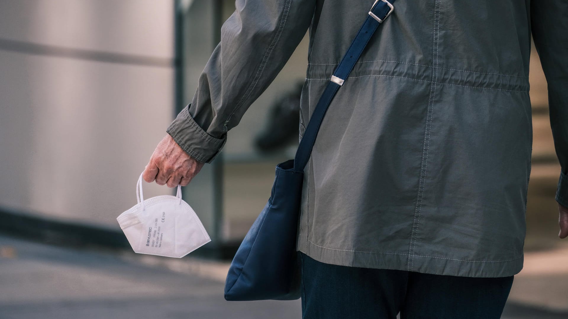 Person hält FFP2-Maske in der Hand (Symbolbild): Die Maskenpflicht in öffentlichen Einrichtungen zählt zum Basisschutz. Person hält FFP2-Maske in der Hand (Symbolbild): Die Maskenpflicht in öffentlichen Einrichtungen zählt zum Basisschutz.
