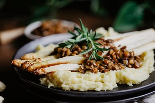 Die Vinaigrette aus Belugalinsen, Leinöl und Balsamico kommt kurz vorm Servieren über Ofenspargel mit Stampfkartoffeln.