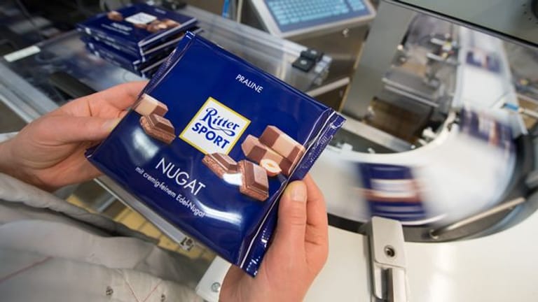 Eine Mitarbeiterin prüft die Verpackung einer Tafel Schokolade (Symbolbild): Das Unternehmen will weiter Geschäfte in Russland machen.