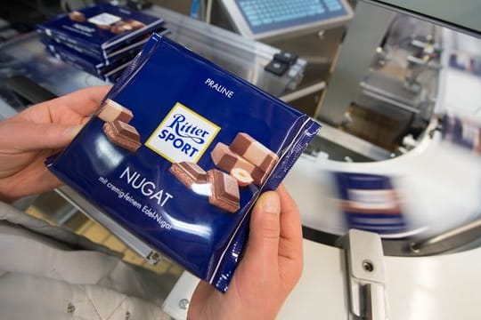 Eine Mitarbeiterin prüft die Verpackung einer Tafel Schokolade (Symbolbild): Das Unternehmen will weiter Geschäfte in Russland machen. Eine Mitarbeiterin prüft die Verpackung einer Tafel Schokolade (Symbolbild): Das Unternehmen will weiter Geschäfte in Russland machen.