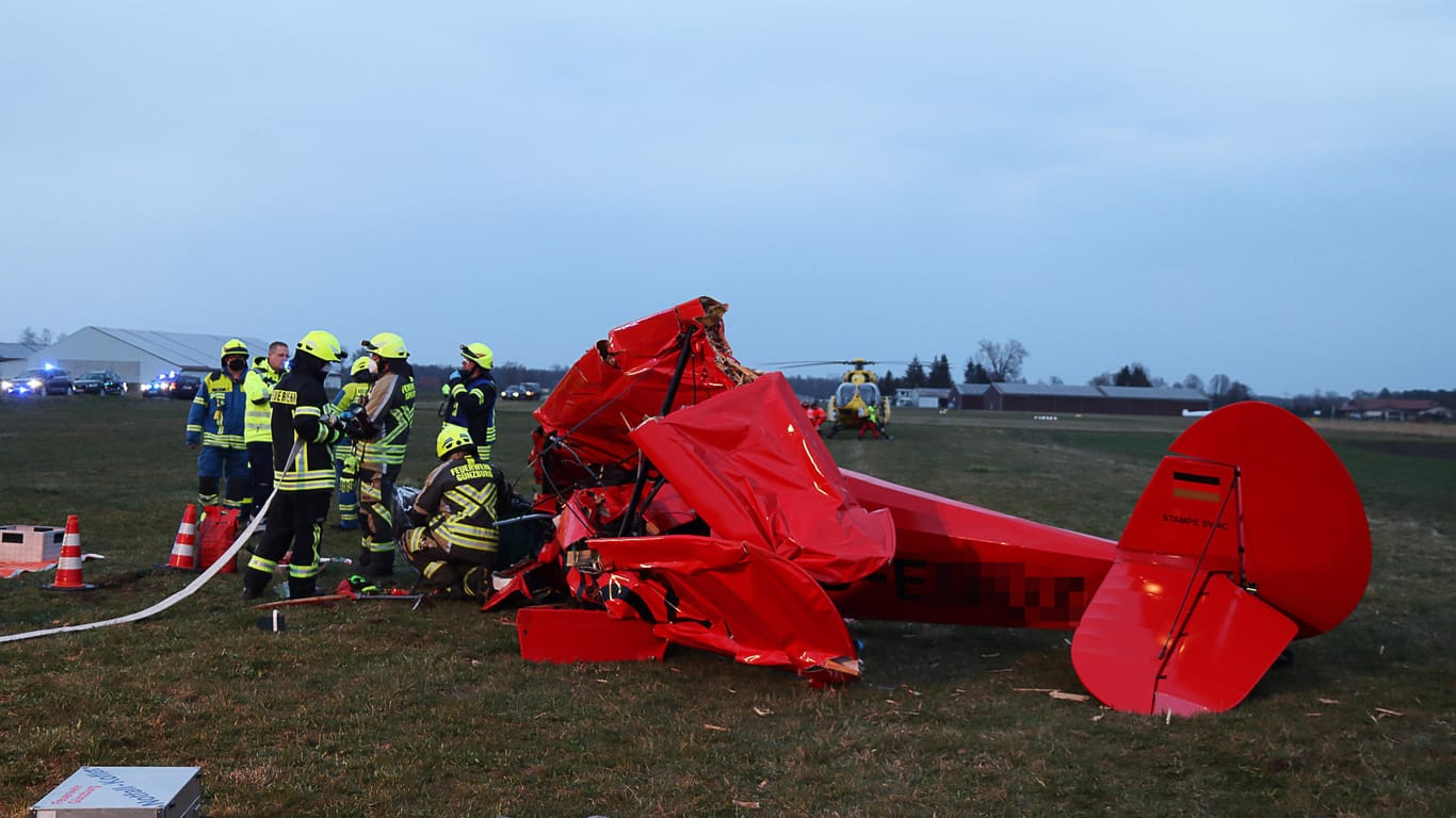 Feuerwehrleute sind am Absturzort eines Sportflugzeugs im Einsatz. Ein Pilot ist in einem Doppeldecker im bayerischen Günzburg abgestürzt und schwer verletzt worden