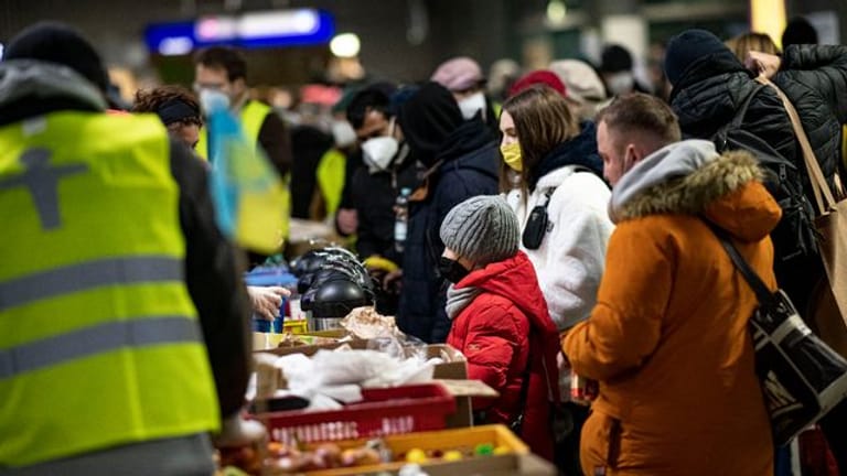 Freiwillige Helfer verteilen am Berliner Hauptbahnhof Essen an Menschen aus der Ukraine.