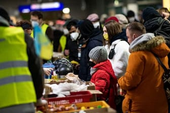 Freiwillige Helfer verteilen am Berliner Hauptbahnhof Essen an Menschen aus der Ukraine.